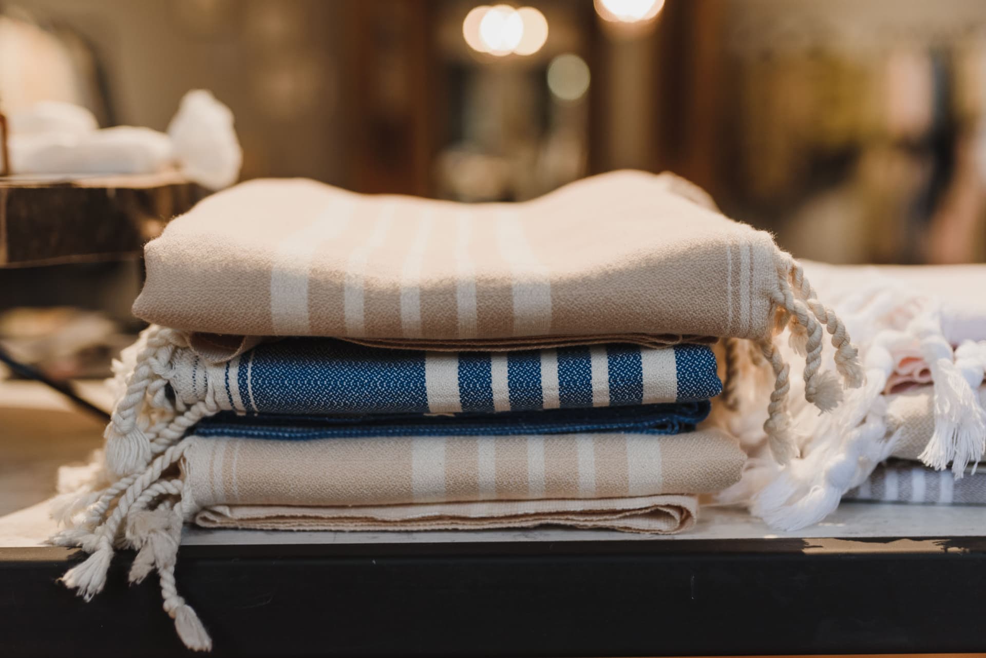 A neatly folded stack of beige and blue striped textiles resting on a table.